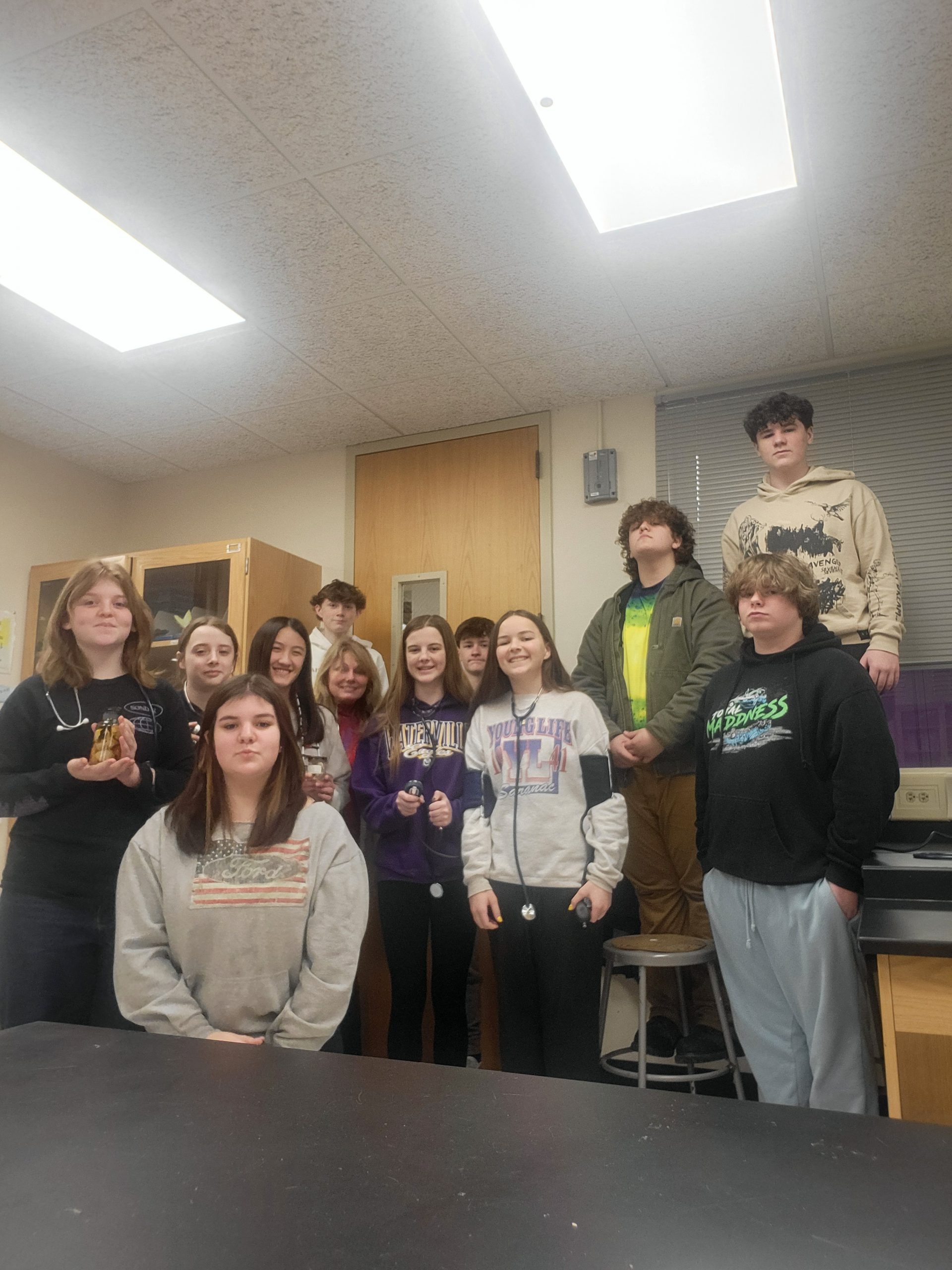 A group of students posing together, smiling at the camera. They are standing close, some with arms around each other, showing a sense of camaraderie and teamwork.