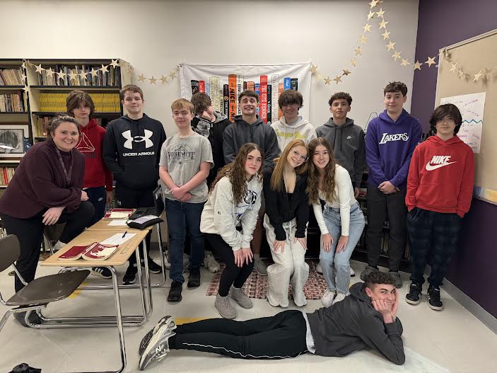 A group of students posing together, smiling at the camera. They are standing close, some with arms around each other, showing a sense of camaraderie and teamwork.