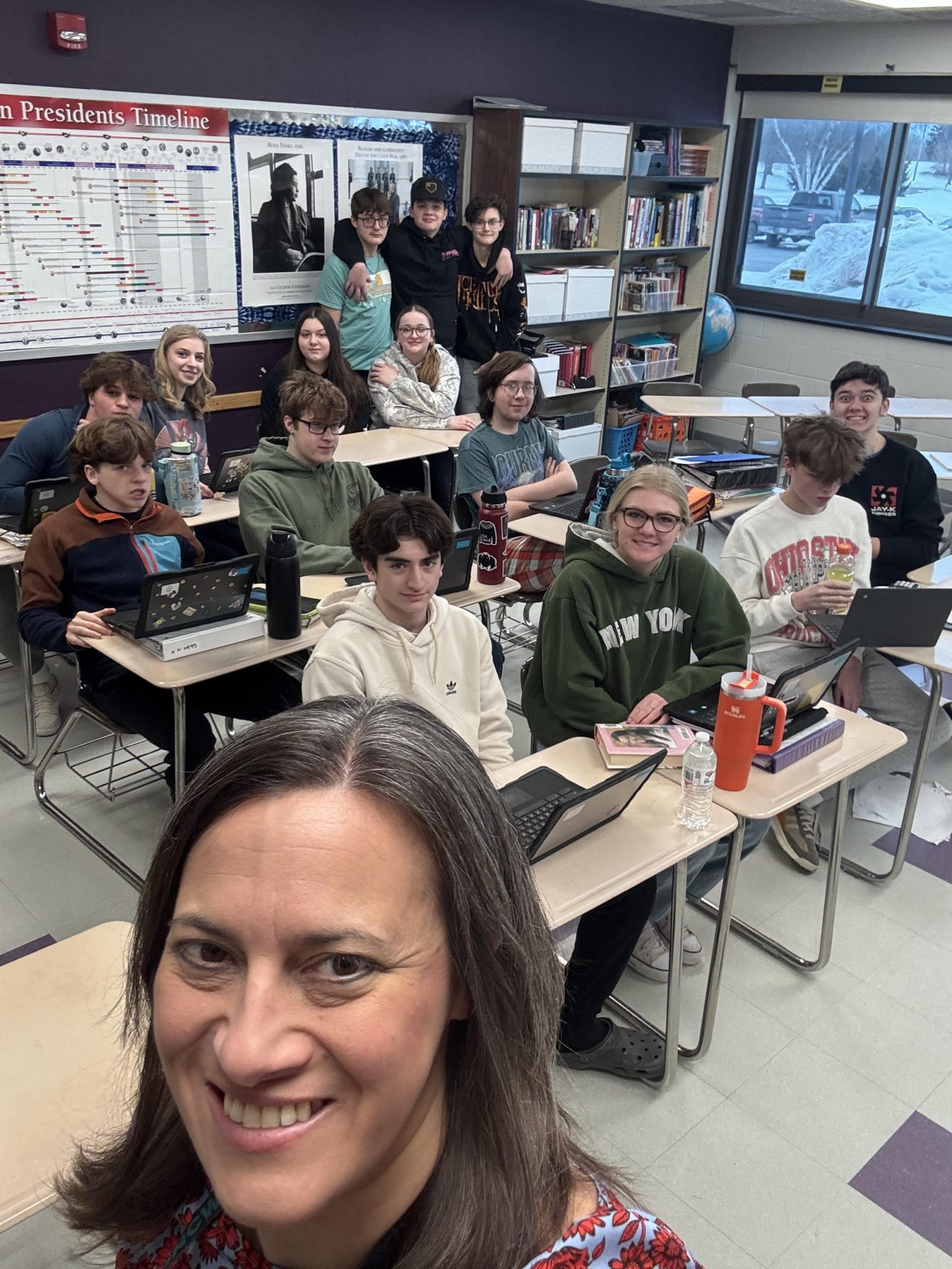 A group of students posing together, smiling at the camera. They are standing close, some with arms around each other, showing a sense of camaraderie and teamwork.