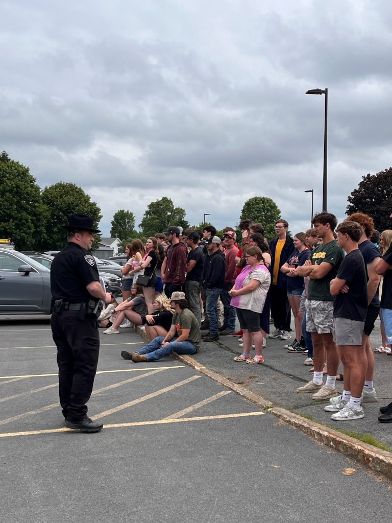 photo of police officer speaking with students about distracted driving