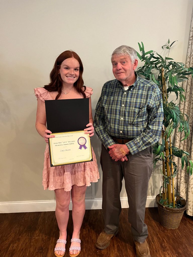 Photo of student holding a certificate along with the sponsor