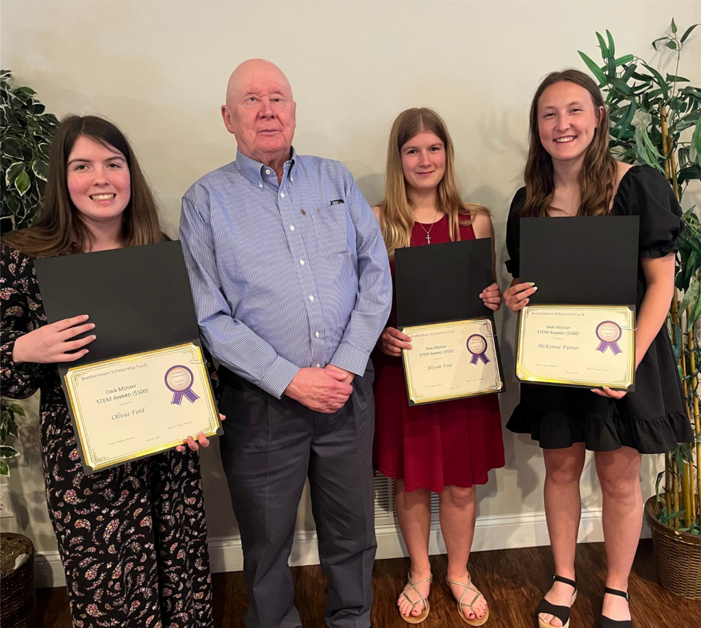 Photo of three students holding certificates along with teacher Mr. Stockwell