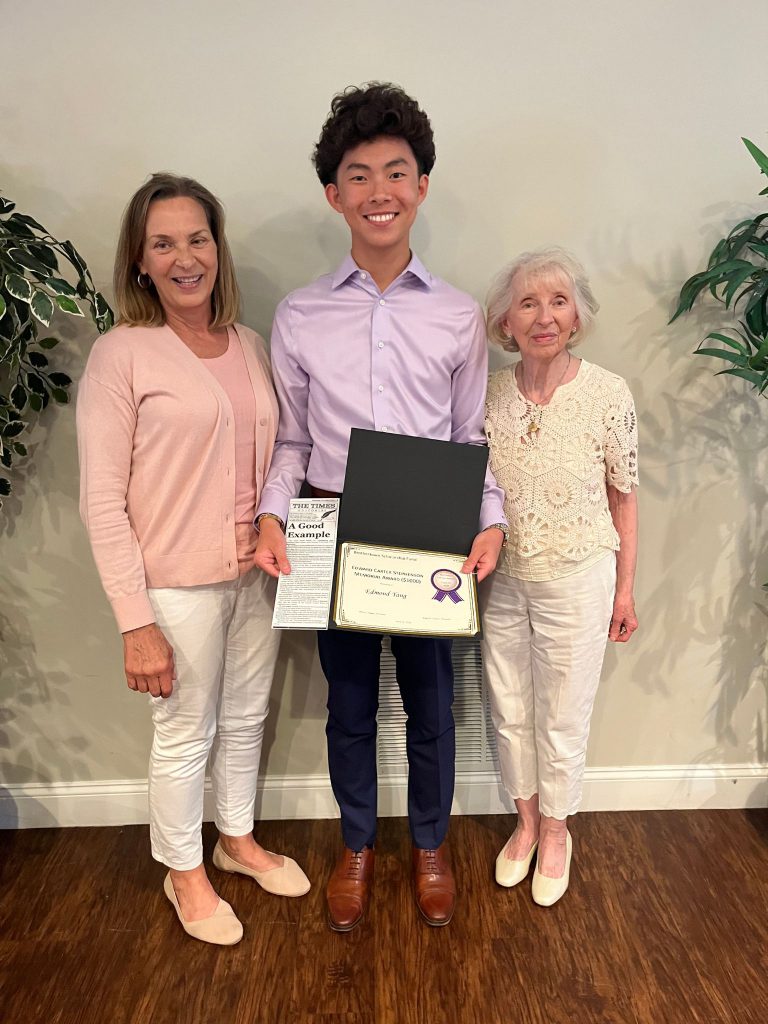 Photo of student holding a certificate with two sponsors