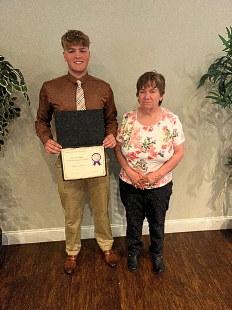 Photo of student holding certificate with sponsor from Pomeroy family
