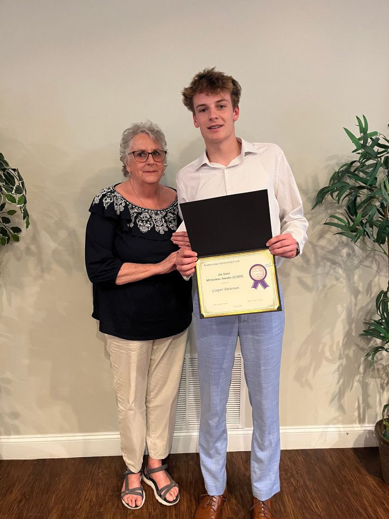 Photo of student holding certificate along with sponsor from the Kane family