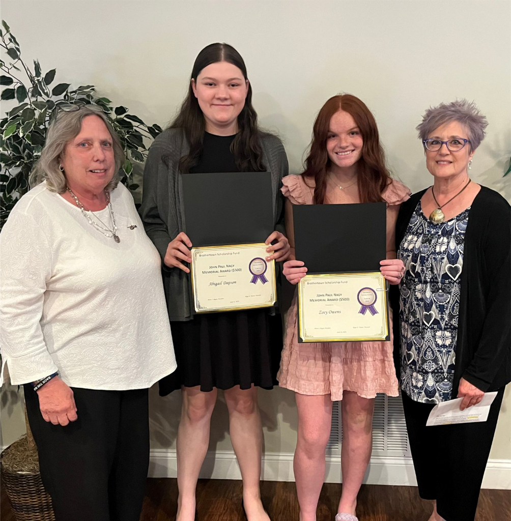 Photo of two students holding certificates and two sponsors from the Nagy family