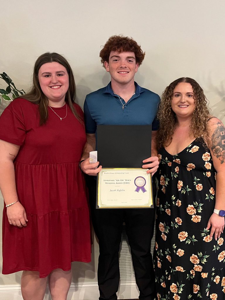 Student holding a certificate along with two sponsors present