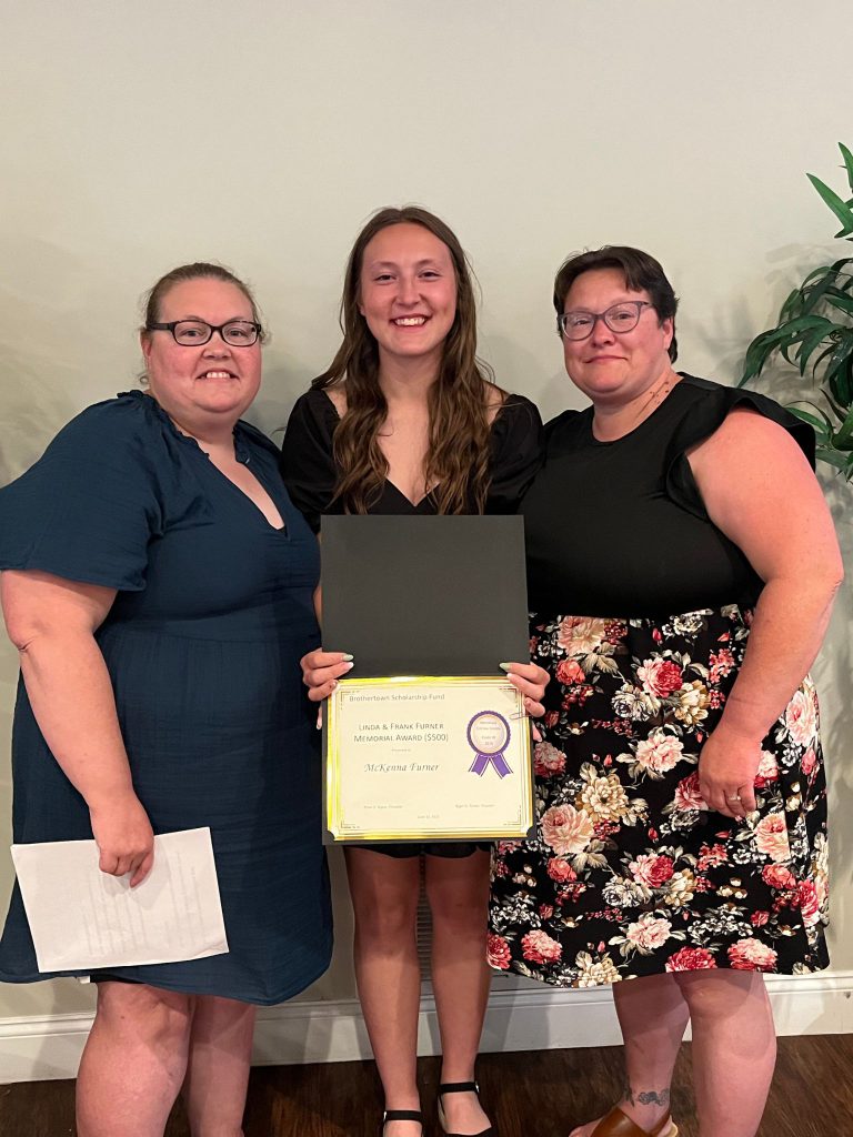 Photo of student holding a certificate and sponsors from the Furner family