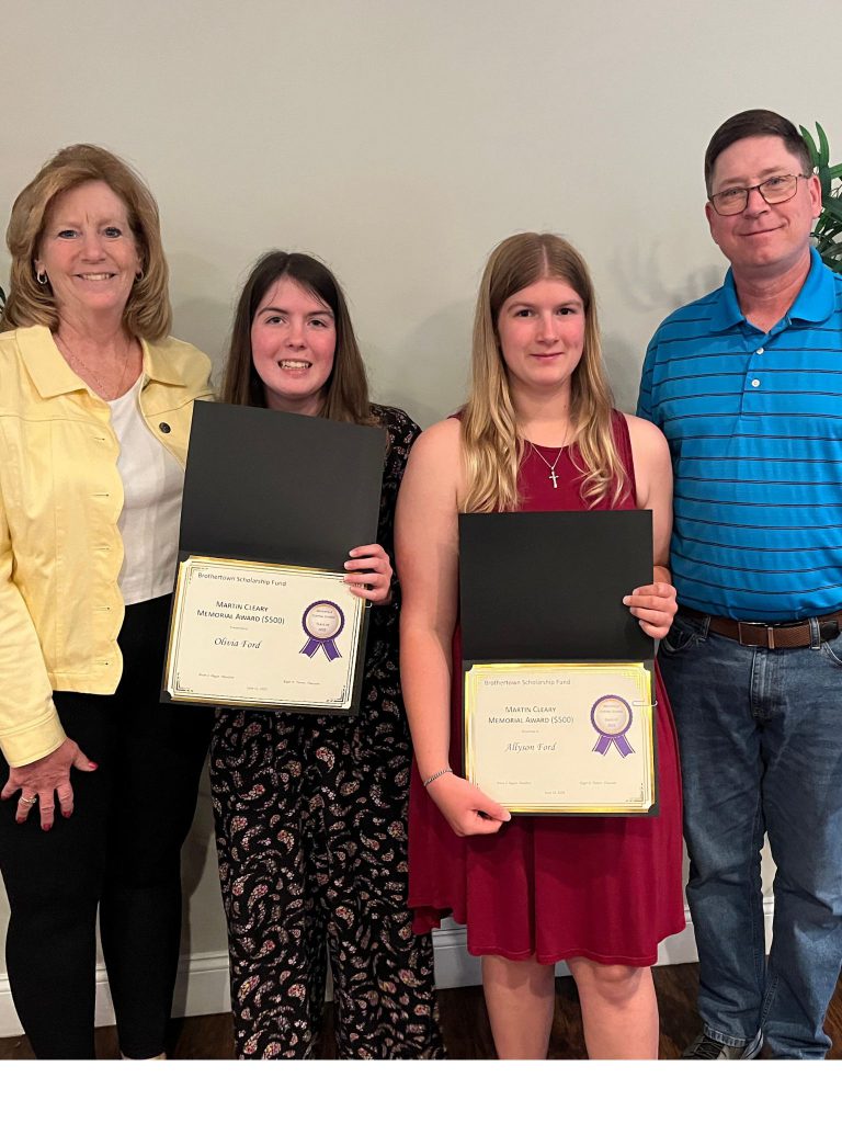 Photo of two students holding certificates along with two sponsors