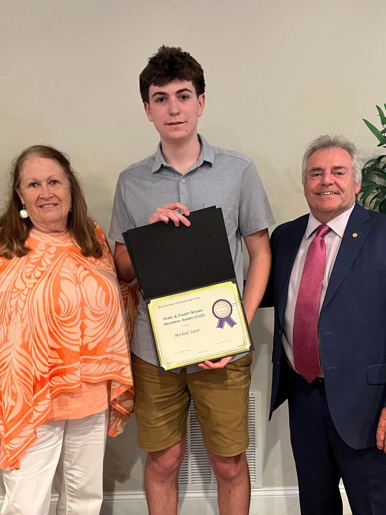 Photo of student holding certificate with two sponsors present