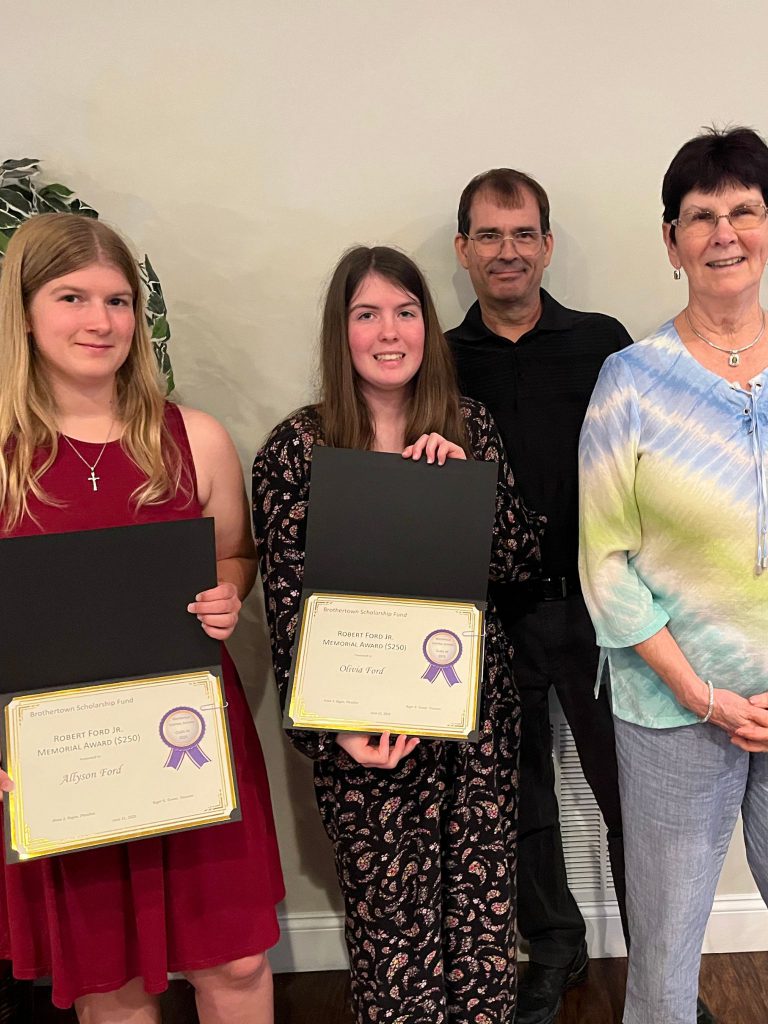 Photo of two students holding certificates along with two sponsors