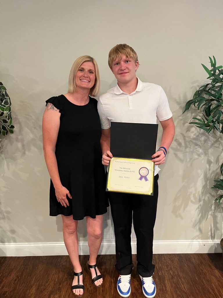Photo of student holding a certificate along with sponsor