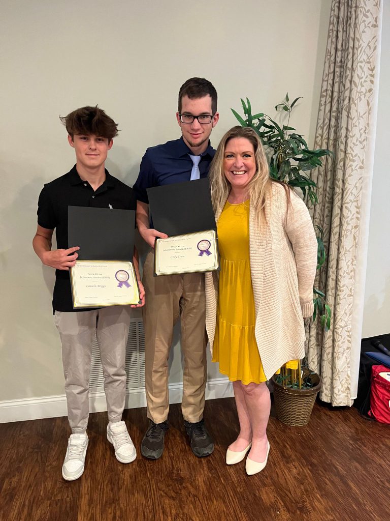 Photo of two students holding certificates along with sponsor of award