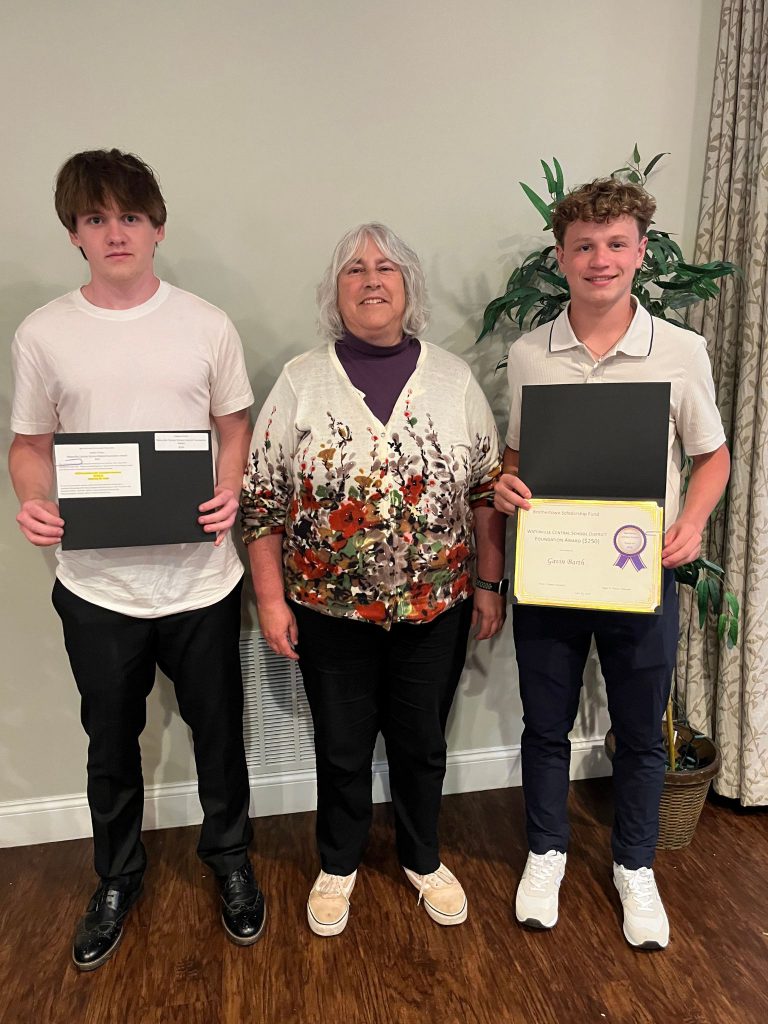 Photo of two students holding certificates along with the sponsor