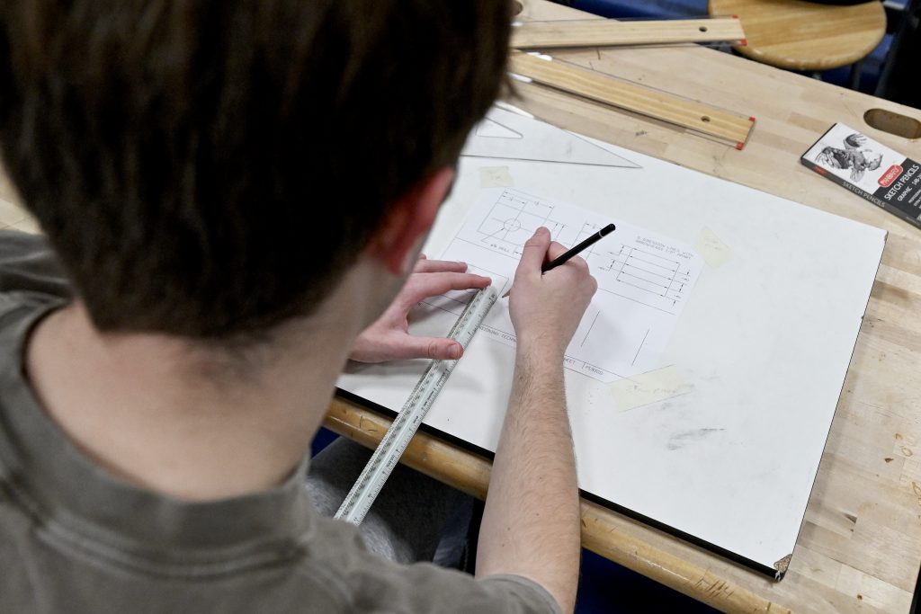 student using a ruler and pen