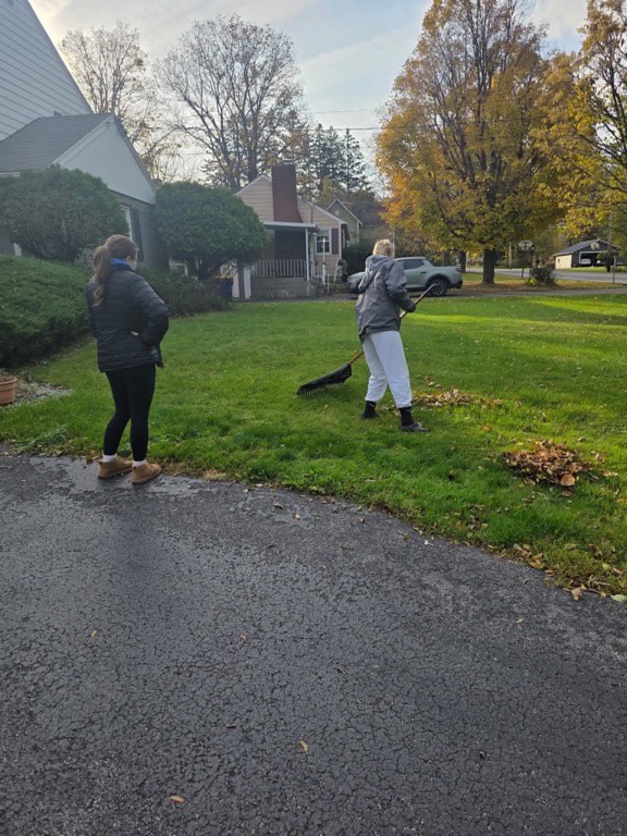 two students raking leaves